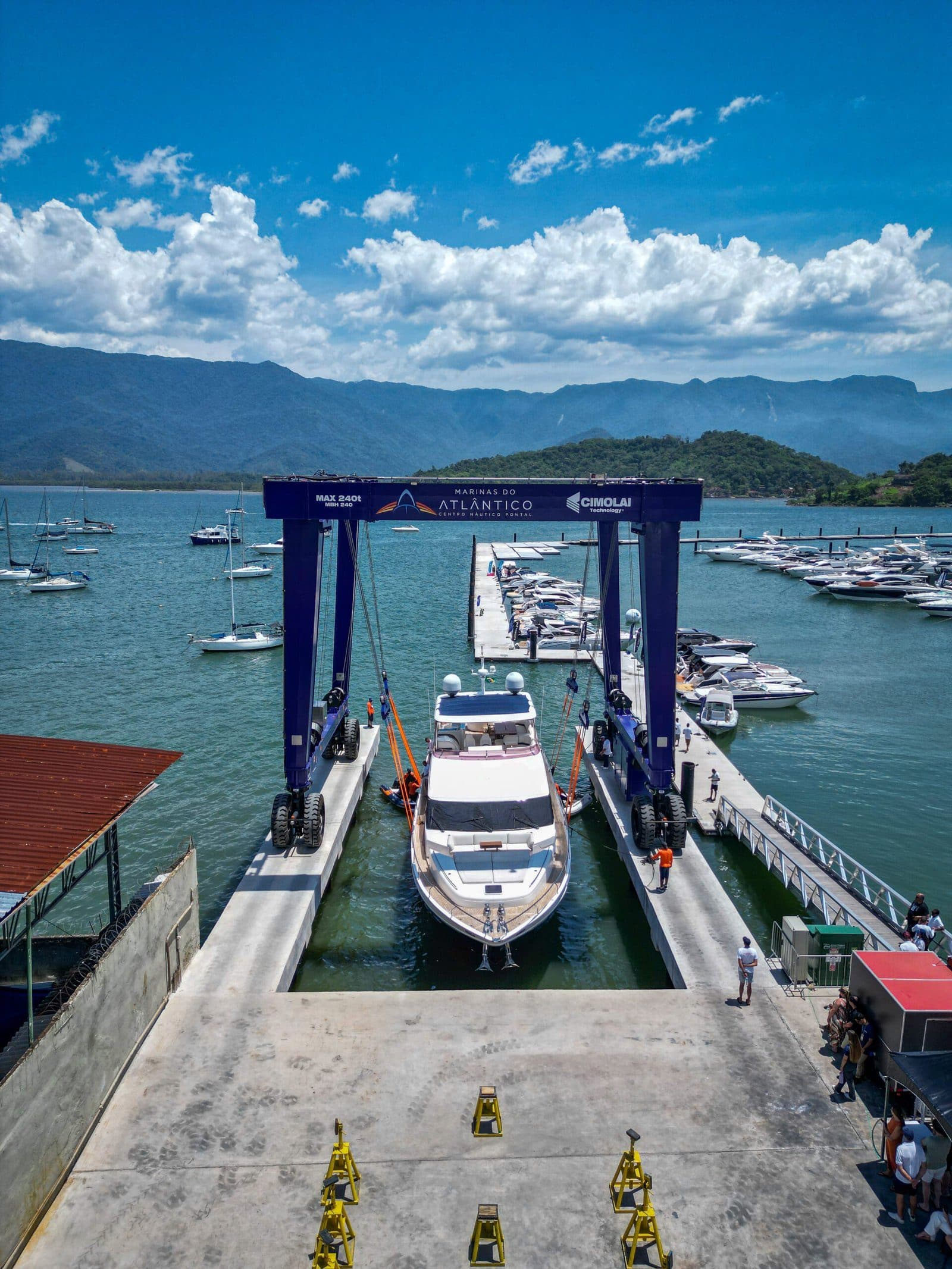 Vista do alto do berço do travel lift, com uma embarcação entrando entre as cintas e o pátio de serviço em primeiro plano