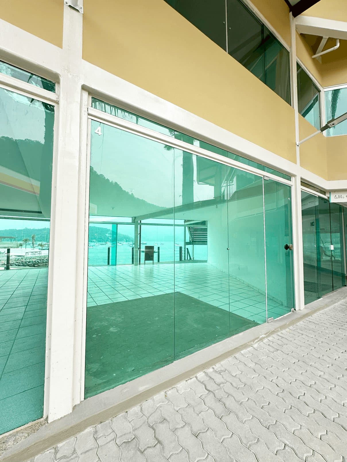 Unidade comercial vazia, com fachada de vidro e piso acabado